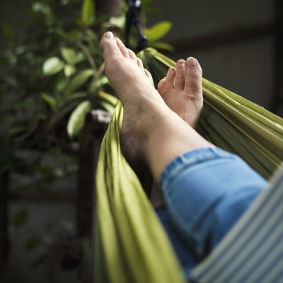 Woman lying on hammock chilling reading book